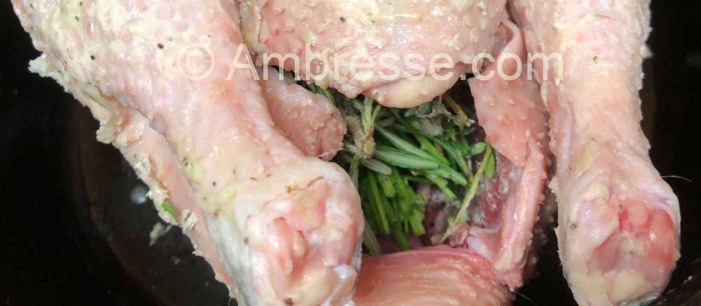 American Bresse bird ready for the oven with bouquet garni in the cavity and skin covered with herbed ghee.